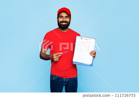 Indian delivery worker with clipboard on blue backdrop Indian delivery worker with clipboard on blue backdrop 111726755