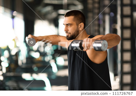 Young Muscular Man Doing Dumbbell Lateral Raise Exercise At Gym 111726767
