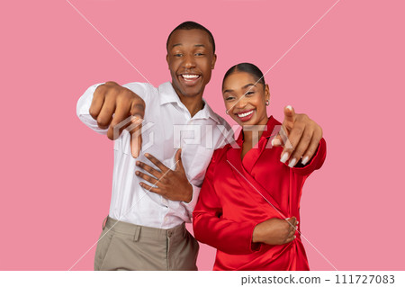 Joyful african american couple pointing at camera with friendly gesture 111727083