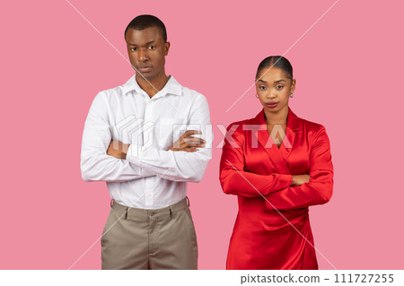 Serious black couple with arms crossed in formal attire 111727255