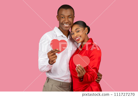 Smiling african american couple holding red hearts, feeling love 111727270