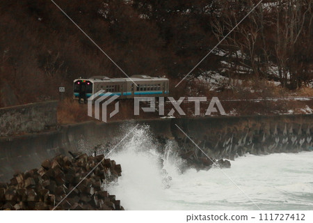 A train running along the sea-splashed coast 111727412
