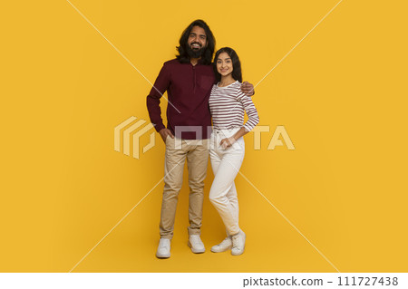 Cheerful young indian couple posing on yellow background, full length 111727438