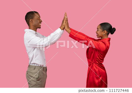 Happy black couple in white and red giving high-five, side view 111727446