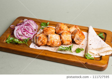 Lamb skewers with grilled vegetables and pita bread on a wooden board. Lamb skewers with grilled vegetables and pita bread on a wooden board. 111727595