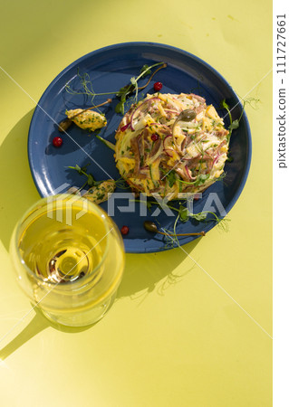 Seafood salad with white wine on blue plate, perfect for a refreshing meal. 111727661