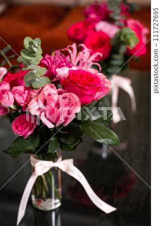 Vibrant Pink and Red Roses in Glass Vase on Black Background, Ideal for Valentines or Mothers Day Vibrant Pink and Red Roses in Glass Vase on Black Background, Ideal for Valentines or Mothers Day 111727695