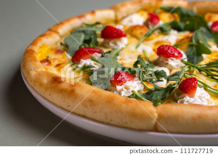 Freshly Baked Pizza with Strawberries, Cream Cheese, and Arugula on White Plate - Summer Party Theme 111727719