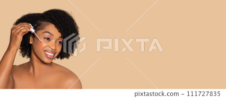 Black woman applying serum for glowing skin care Black woman applying serum for glowing skin care 111727835