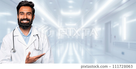 A bearded male doctor with a friendly smile is gesturing with an open hand A bearded male doctor with a friendly smile is gesturing with an open hand 111728063