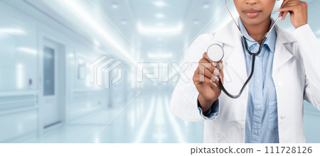 A confident woman doctor in a white coat holding a stethoscope A confident woman doctor in a white coat holding a stethoscope 111728126