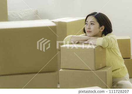 搬家時疲憊的年輕女子靠在紙板上 111728207