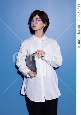 藍色背景下拍攝的一位戴眼鏡的年輕女子 藍色背景下拍攝的一位戴眼鏡的年輕女子 111730831