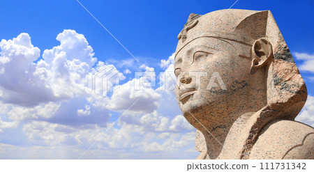 Horizontal banner with face of Sphinx in Famous landmark Serapeum of Alexandria, Alexandria, Egypt, North Africa. Sphinx in Roman temple Serapeum. On blue sky background Horizontal banner with face of Sphinx in Famous landmark Serapeum of Alexandria, Alexandria, Egypt, North Africa. Sphinx in Roman temple Serapeum. On blue sky background 111731342