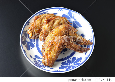 Overhead shot of fried chicken wings against a black background 111732110