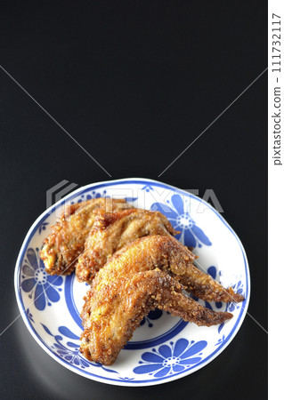 Overhead shot of fried chicken wings against a black background 111732117