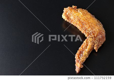 Deep-fried chicken wings photographed against a black background Deep-fried chicken wings photographed against a black background 111732159
