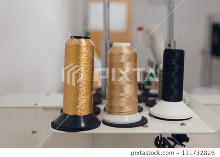 threads of different colors on an embroidery machine. hobby, creative girl 111732826