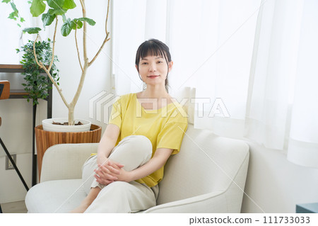 一個女人在窗邊的沙發上放鬆 一個女人在窗邊的沙發上放鬆 111733033