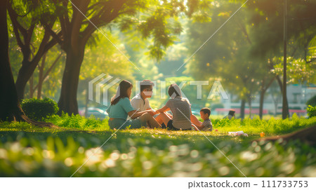 AI-generated content. Happy young Asian family dad, mom and two children daughter and son sitting in a meadow on the grass in the park on a warm sunny day, having fun on a day off. 111733753