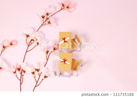 用絲帶包裹的文憑和放在課桌上的櫻花 111735188