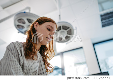 Close up of scared teenage patient, waitng for test results. Anxiety, worry and loneliness of teenager in hospital. Emotional support for ill young woman. 111735337