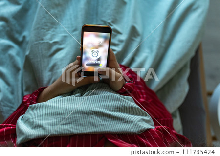 Woman setting alarm before going to sleep. Concept of sleep routine. Insomnia a sleep problems among adults. 111735424
