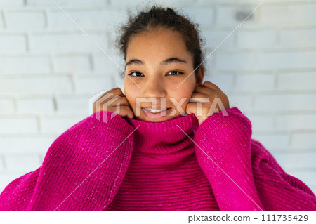 Portrait of beautiful curvy woman holding collar of turtleneck sweater, looking at camera. Portrait of beautiful curvy woman holding collar of turtleneck sweater, looking at camera. 111735429