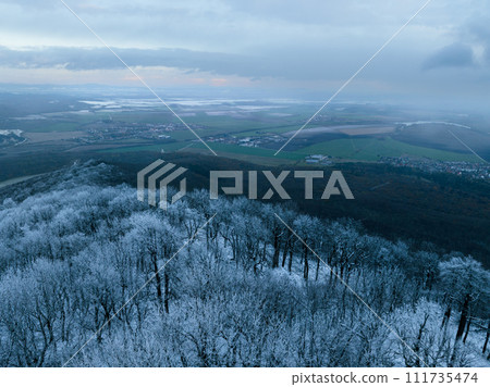 Aerial view of winter forest with frost line, freeze line. Freezing on hills. Drone view of snowy landscape. 111735474