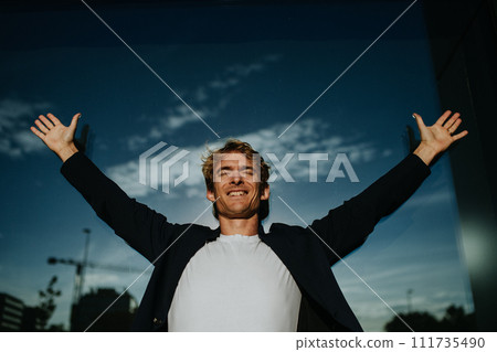 Portrait of handsome mature man with blond hair and closed eyes, standing outdoors in front of reflective wall. 111735490