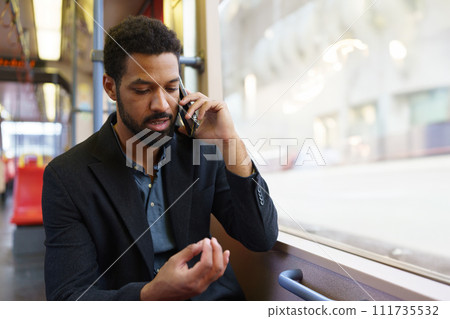 Handsome man traveling by city train, phone calling on smartphone. Single man using dating app. 111735532
