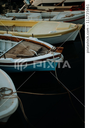 Small boats on calm water, moored in the harbor during sunset. Small boats on calm water, moored in the harbor during sunset. 111735661