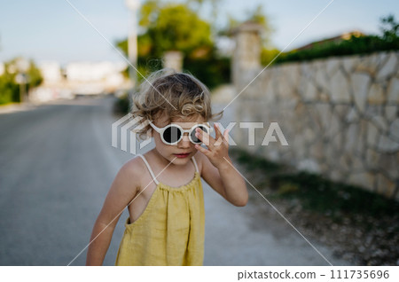 Portrait of blonde girl in summer outfit on walk during summer vacation, concept of beach holiday. 111735696
