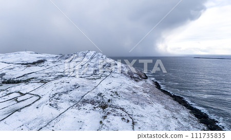 Aerial view of snow covered Dunmore Head, Bunaninver and Lackagh by Portnoo in County Donegal, Ireland. 111735835