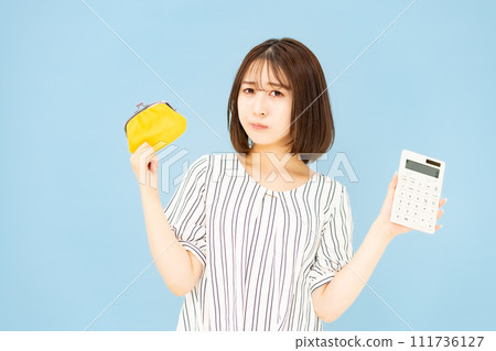 Young woman in her 20s worried about wallet and calculator 111736127