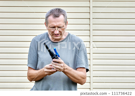 Middle aged man installs drinking water connection pipeline using valve fitting with compression connection. Middle aged man installs drinking water connection pipeline using valve fitting with compression connection. 111736422