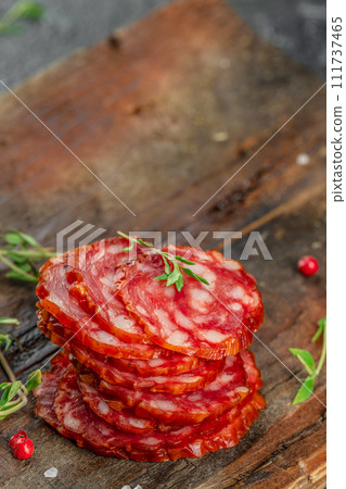 Salami sausage slices dry cured pork sausage chorizo on a wooden board 111737465