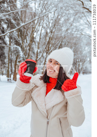 happy woman with coffee cup outdoors at winter cold day 111738019