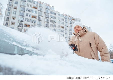 man cleaning car out of snow man cleaning car out of snow 111738098
