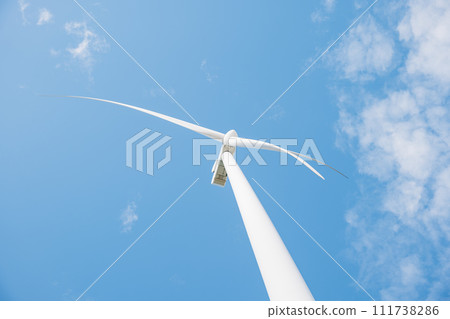 A serene scene of windmill farm turbines on a mountain demonstrates clean energy innovation. Modern technology supports sustainable development under the endless blue sky. 111738286