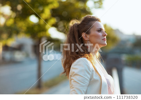 pensive stylish woman in dress and jacket in city pensive stylish woman in dress and jacket in city 111738320