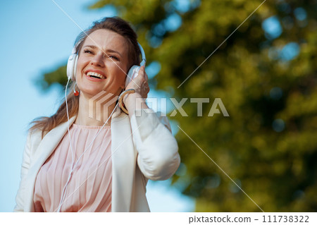 happy 40 years old woman in dress and jacket in city 111738322