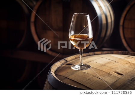 Wine Glass with Chardonnay Grapevine tasting. Vino Degustation in wine cellar with Wine barrels. 111738586