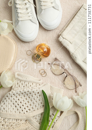 Beige female clothes and accessories on beige background, top view Beige female clothes and accessories on beige background, top view 111738731