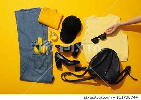 Female clothes, shoes, accessories and hand on yellow background, top view 111738744