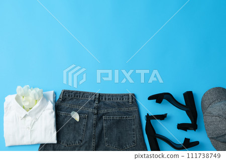 Female spring outfit with accessories on blue background, space for text 111738749