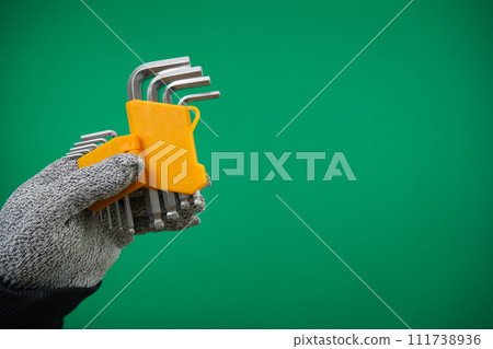 Set of hex keys in hand on green background advertising Green background chromakey free space 111738936