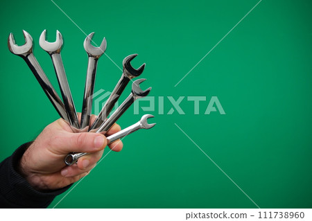 Metal double-sided open-end wrench with chrome-plated tool for connecting and disconnecting threaded connections. advertising Green background chromakey free space Metal double-sided open-end wrench with chrome-plated tool for connecting and disconnecting threaded connections. advertising Green background chromakey free space 111738960