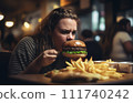 Fat girl eating hamburger in fast food restaurant.  111740242