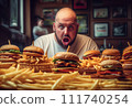 Fat man eating hamburger in fast food restaurant.  111740254